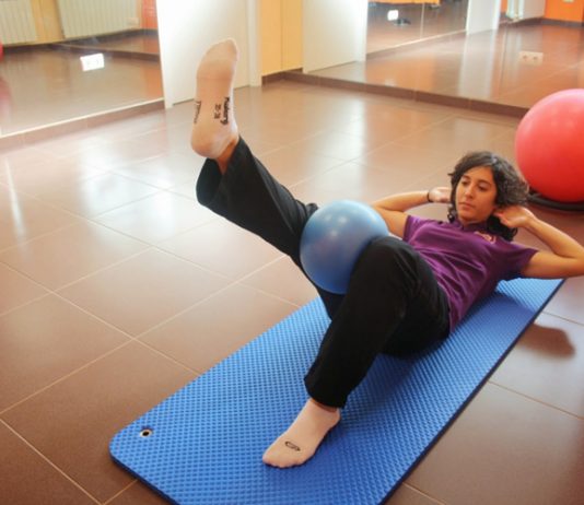 Ejercicio de Pilates con pelota entre las piernas